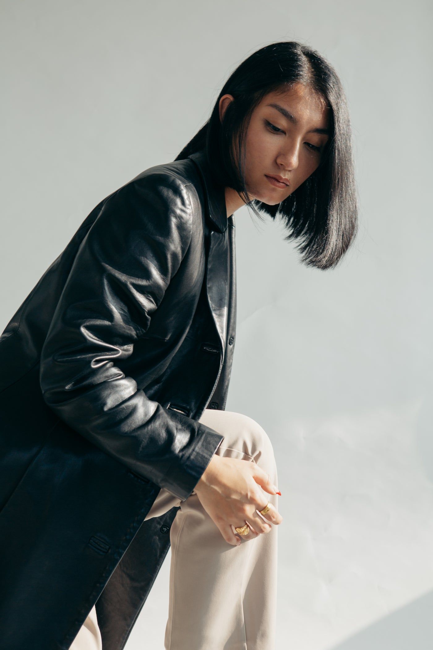 Femme en veste de cuir noire et pantalon clair