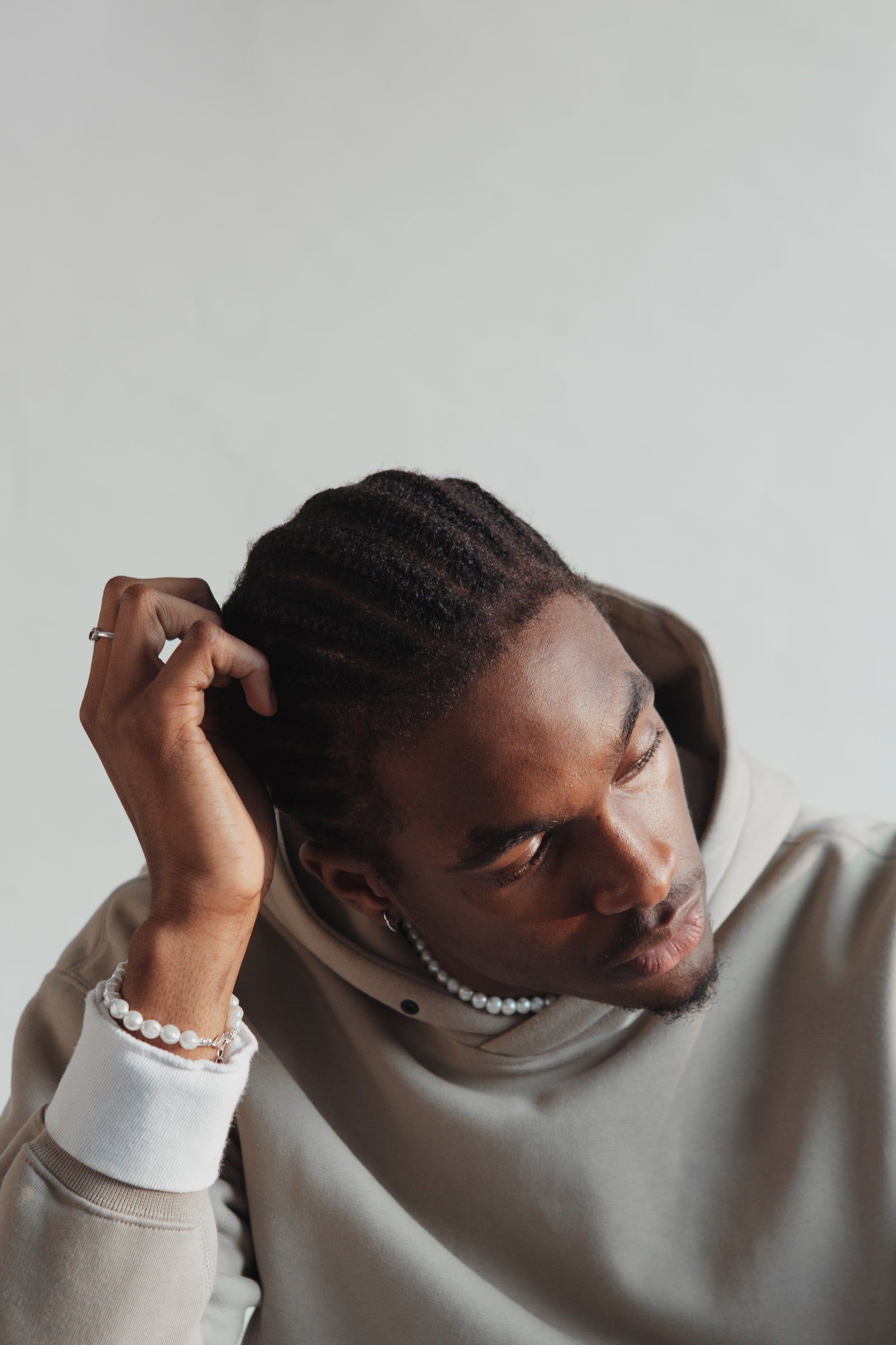 Homme en hoodie avoine, main dans les cheveux